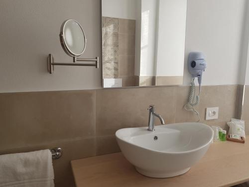 a bathroom with a sink and a mirror on a counter at Hotel Pedretti in Branzi