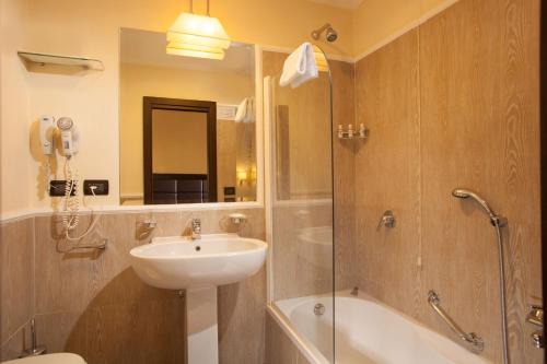 a bathroom with a sink and a shower and a toilet at Hotel Buenos Aires in Rome
