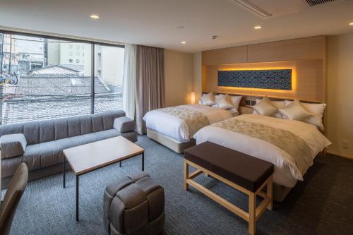 a hotel room with two beds and a couch at Villa Sanjomuromachi KYOTO in Kyoto