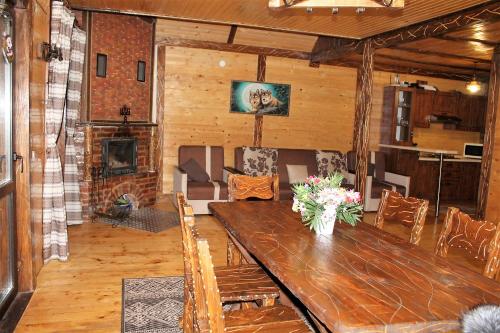 a living room with a wooden table and a fireplace at Szlachta Cottage in Bukovel