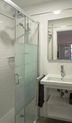 a bathroom with a glass shower and a sink at La Palmera Hotel Boutique in Las Palmas de Gran Canaria