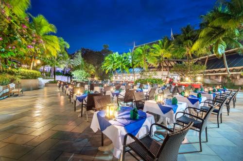 a restaurant with tables and chairs at night at Chada Thai Village in Ao Nang Beach