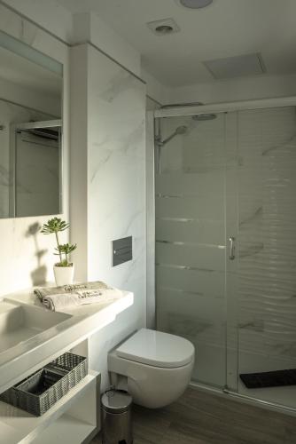 a bathroom with a toilet and a glass shower at La Palmera Hotel Boutique in Las Palmas de Gran Canaria
