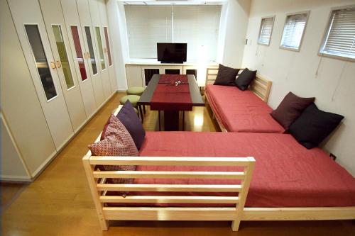a room with two beds and a table in it at Guest room Kamakura Nagomi -Camellia- in Kamakura