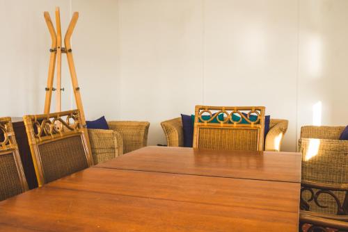 uma sala de jantar com uma mesa de madeira e cadeiras em Koensrust Beach Shack em Vermaaklikheid