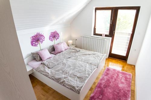 1 dormitorio con 1 cama grande con almohadas moradas en D&J house en Ormoz