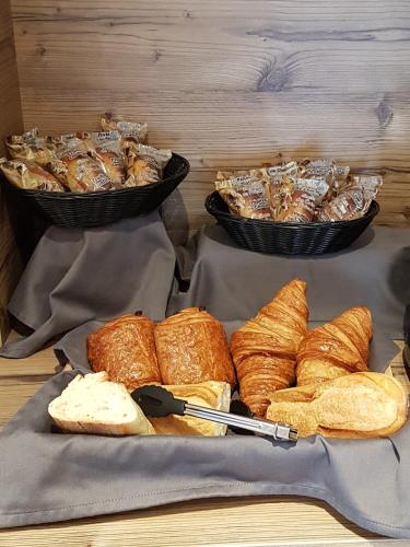 a table with two trays of bread and pastries at Hôtel du Soleil in Aillon-le-Jeune