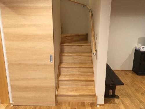 a stairway leading up to a room with wooden stairs at Rental Villa Ooishiso in Fujikawaguchiko