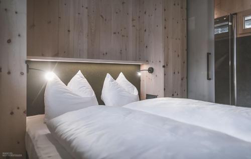 1 cama blanca grande con sábanas y almohadas blancas en nancy's Holiday Homes Dolomites, en Rasun di Sotto