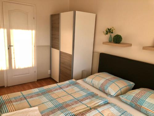 a bedroom with a bed and a cabinet at RT Home Vendégház in Szombathely