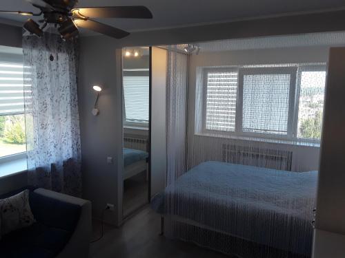 LBE apartments في نارفا: غرفة نوم بسرير ومروحة سقف