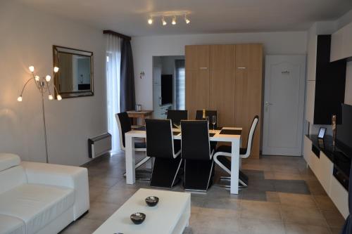 a dining room and living room with a table and chairs at Vakantiehuis Jonckershof in Middelkerke