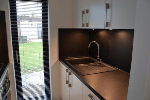 a kitchen with a sink and a window at Vakantiehuis Jonckershof in Middelkerke