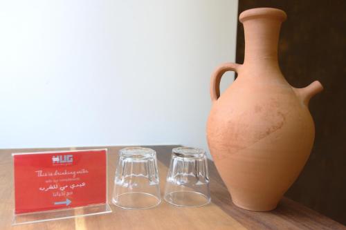 a vase and two glasses sitting on a table at Hamra Urban Gardens in Beirut