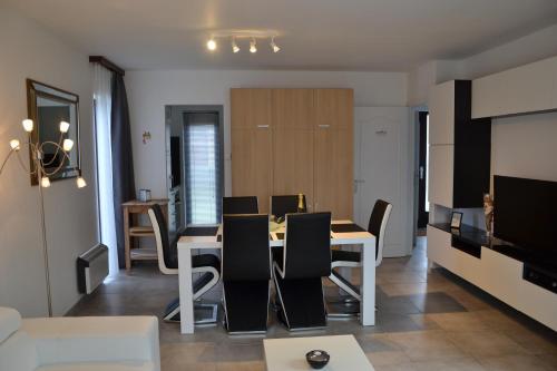 a dining room and living room with a table and chairs at Vakantiehuis Jonckershof in Middelkerke