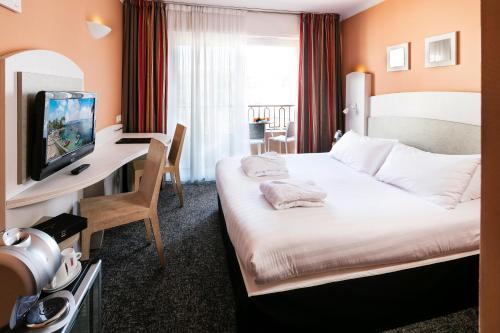 una camera d'albergo con letto e scrivania di Best Western Astoria a Juan-les-Pins