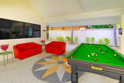 a living room with a pool table and red chairs at Sweet Villas Pattaya in Pattaya South
