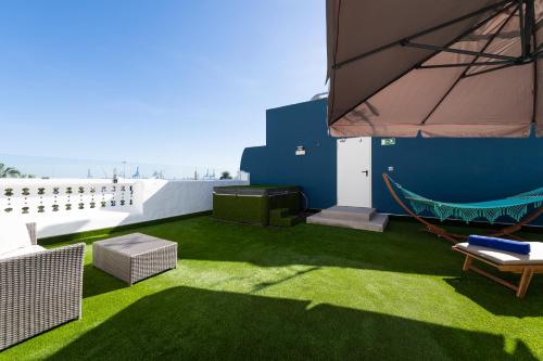 un patio con césped verde y una hamaca en el techo en HD Acuario Lifestyle, en Las Palmas de Gran Canaria