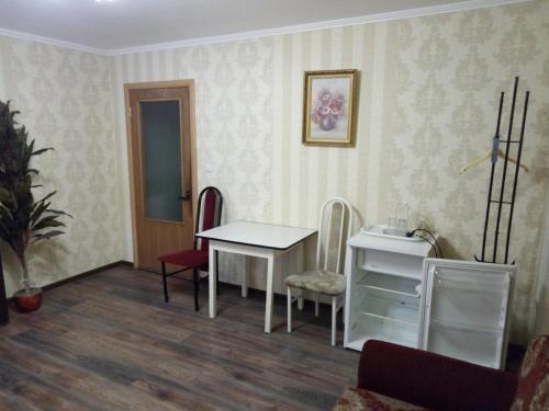 a room with a table and chairs and a desk at Hotel Gloria in Cherepovets