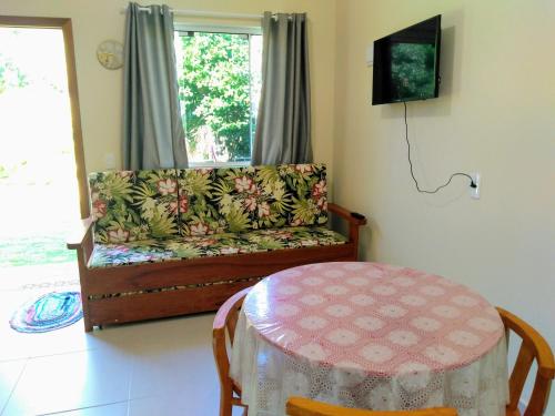 a living room with a couch and a table at Moradas Cantinho da Guarda in Guarda do Embaú