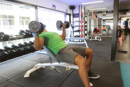 a man is lifting weights in a gym at Hamra Urban Gardens in Beirut