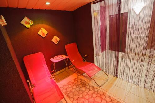 two red chairs and a table in a room at ibis Sète Balaruc les Bains Bien-être et Spa in Balaruc-les-Bains