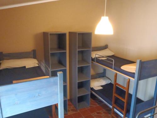 a room with two bunk beds and a lamp at Albergue Rural de Guara in Alquézar