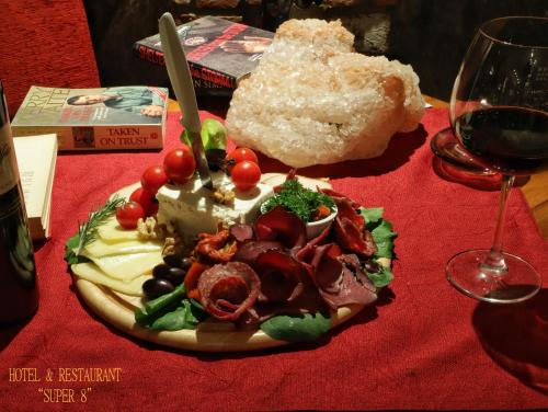 a plate of food on a table with a glass of wine at Hotel Super 8 in Skopje