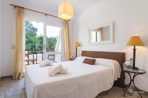 1 dormitorio con 2 camas y ventana grande en Apartamento Mercuri en Puerto de Alcúdia