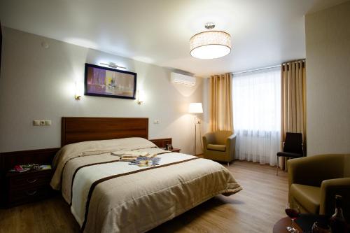 Habitación de hotel con cama y TV en la pared en APART-HOTEL VEGUS, en Uralsk
