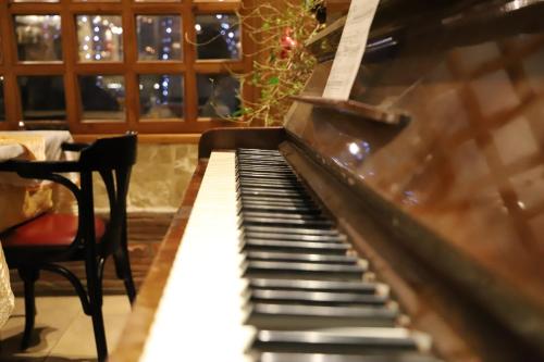 an old piano in a room with a christmas tree at Hotel Super 8 in Skopje