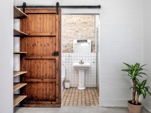 a bathroom with a toilet and a wooden door at Loft by the Beach in Valencia