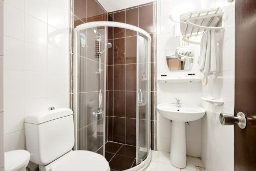 DİNAR HOTEL في إسطنبول: حمام مع دش ومرحاض ومغسلة