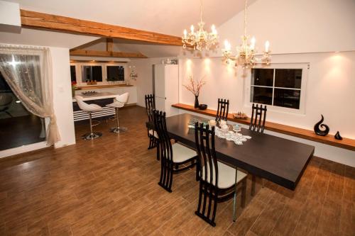 een eetkamer en een woonkamer met een tafel en stoelen bij Angel's Nest Apartment in Komenda
