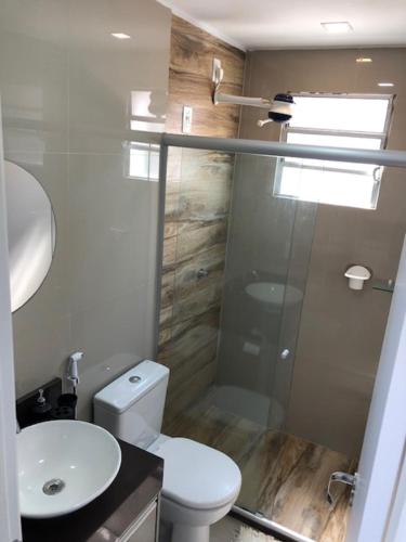 ein Bad mit einem WC und einer Glasdusche in der Unterkunft Apto 301 in Caruaru