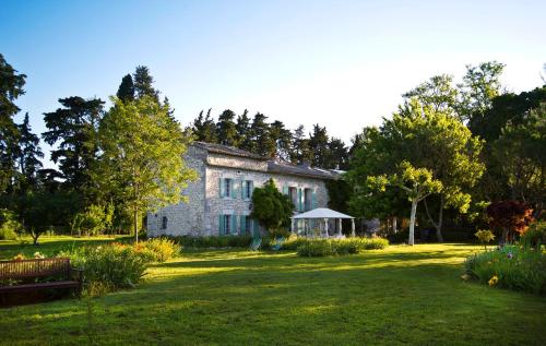 ein altes Steinhaus mit Garten davor in der Unterkunft Le Mas d'Hermès in Plan-dʼOrgon