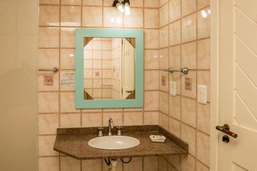 uma casa de banho com um lavatório e um espelho em Fenícia Palace Hotel em Florianópolis