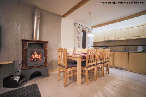 a kitchen with a table and a wood stove at Urocze domki Zakopane in Zakopane