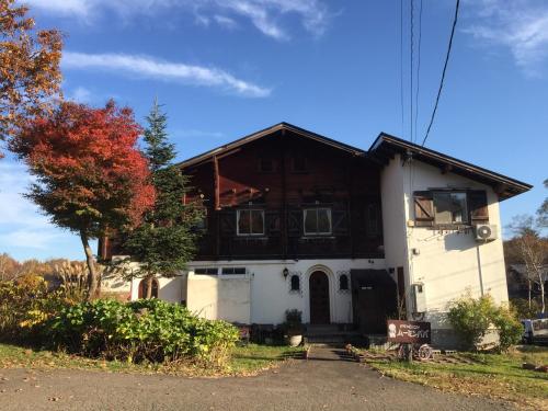 a house with a wooden roof at Pension Moomin Papa in Myoko