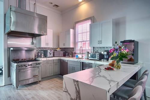 a kitchen with white cabinets and a marble counter top at Five BR - Sleeps 10! Steps from French Quarter in New Orleans