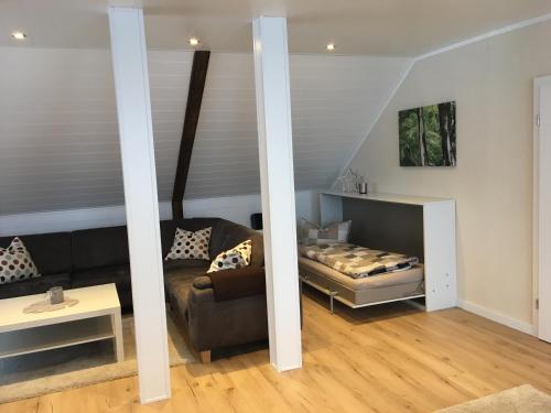 sala de estar con cama y sofá en Lina's Ferienwohnungen - zwei moderne FeWos mit Sauna im Haus und fantastischem Ausblick en Sankt Andreasberg