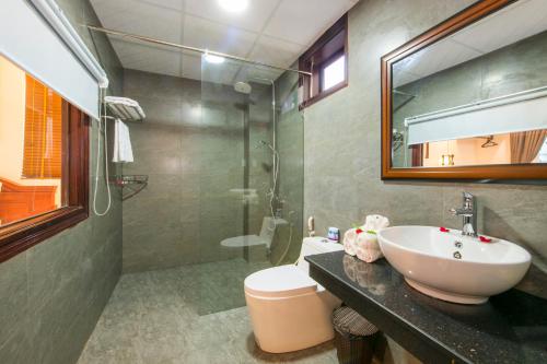 y baño con lavabo, aseo y espejo. en Bonsai Villa Hoi An, en Hoi An