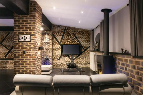 a living room with a couch and a brick wall at Appart-Hotel Léopold Liège Centre in Liège
