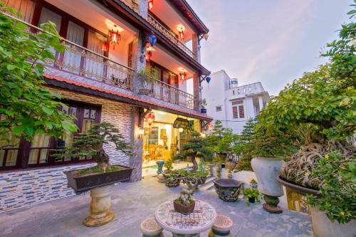 a courtyard with potted plants and a building at Bonsai Villa Hoi An in Hoi An