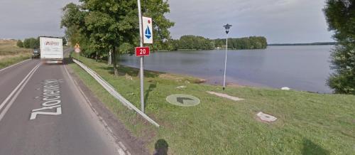 a road with a sign on the side of a river at Pokoje gościnne Venezia in Czaplinek