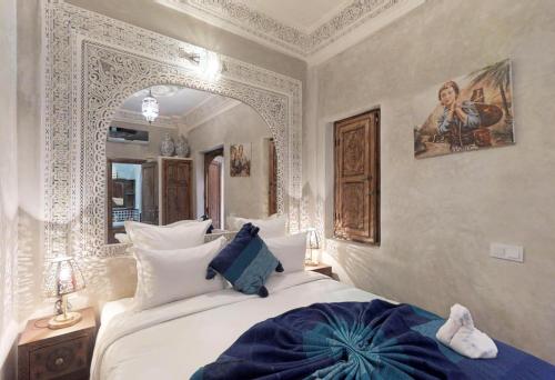 a bedroom with a large white bed and a mirror at Riad Sania By Ghali in Marrakech