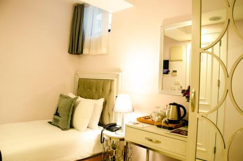 a small bedroom with a bed and a mirror at Primero Hotel in Istanbul