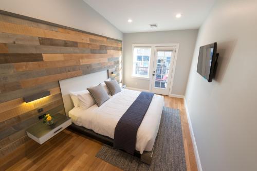 a bedroom with a bed with a wooden accent wall at The Newport Lofts - Brick Market Place in Newport