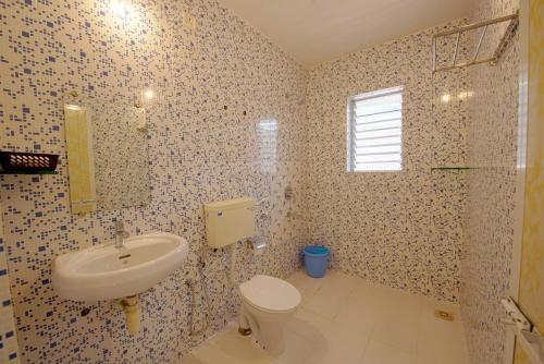 a bathroom with a sink and a toilet at Resort Paloma De Goa in Colva