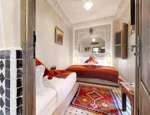 a bedroom with a bed and a rug at Riad Sania By Ghali in Marrakech